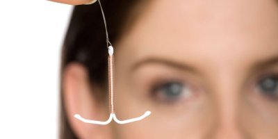 Woman holding up a IUD