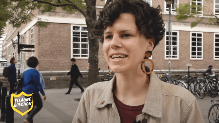 "ellaOne question - woman with short curly hair on street"