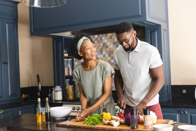 Couple cooking a balanced meal together, representing shared responsibility for reproductive health