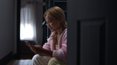 Woman using a phone to get professional medical advice after taking a pregnancy test.