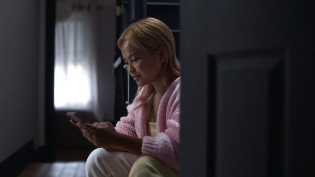 Woman using a phone to get professional medical advice after taking a pregnancy test.
